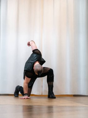 Rock kostümlü bir adam dans figürleri sergiler. Kafasında mohawk olan metal bir adam. Hareket eden adam ve dans eden kollar ve bacaklar..