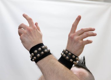 Rock kostümlü bir adam dans figürleri sergiler. Kafasında mohawk olan metal bir adam. Hareket eden adam ve dans eden kollar ve bacaklar..