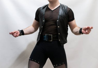 Rock kostümlü bir adam dans figürleri sergiler. Kafasında mohawk olan metal bir adam. Hareket eden adam ve dans eden kollar ve bacaklar..