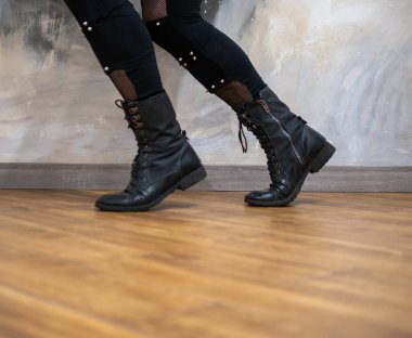 Rock kostümlü bir adam dans figürleri sergiler. Kafasında mohawk olan metal bir adam. Hareket eden adam ve dans eden kollar ve bacaklar..