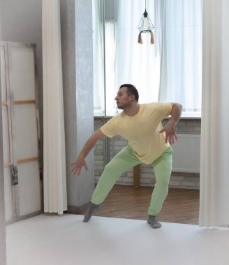 Erkek koreografisi stüdyoda hareket halinde. Dans stüdyosunda dans eden genç adam.