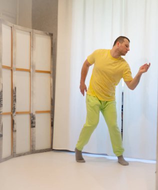 Erkek koreografisi stüdyoda hareket halinde. Dans stüdyosunda dans eden genç adam.