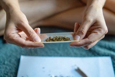 women cannabis smoker rolling marijuana cannabis joint. Drugs narcotic concept.