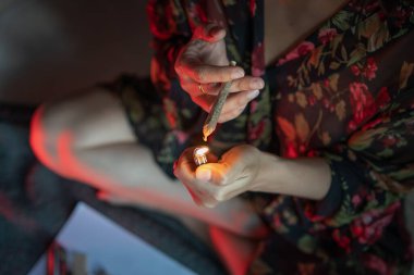 Women preparing lighting up marijuana joint with lighter. cannabis smoker rolling marijuana cannabis joint. Drugs narcotic concept. Legal Marijuana.