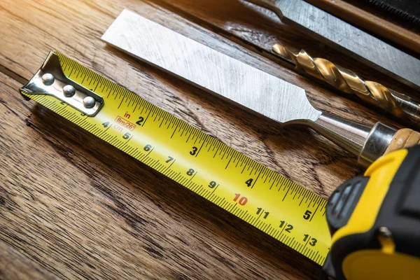 Tape measure with linear-measured markings on wooden background, DIY maker and woodworking concept. selective focus