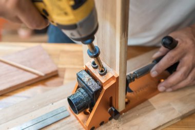 Carpenter use drill bit Pocket hole joinery, or pocket screw joinery, involves drilling a hole at an angle ,make strong joints on wooden plate. D.I.Y and woodworking concept.selective focus.