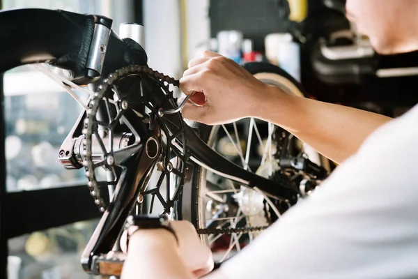 Technician makes adjustments to Crankset and repairing the gearshift on a folding bicycle working in workshop , Bicycle Repair and maintenance concept