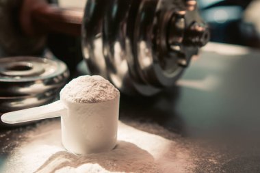 whey protein powder and dumbbell background ,Sports nutrition. Fitness or healthy lifestyle concept.