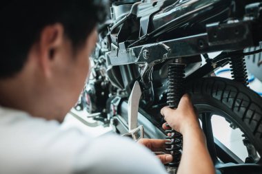 Motosiklet mekanik kontrolü ve arka şok emiciler garajda motosiklet scooter, motosiklet tamiri, bakım ve servis konsepti      