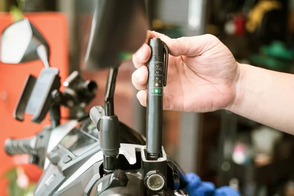 车库里技师用制动液检测工具检查摩托车制动液质量 摩托车维护和维修概念 — 图库照片