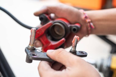 Motosiklet bakım ve onarım konsepti, garajdaki motorun kalibreli kayganlaştırıcı veya disk fren ayarlayıcısı için lastik yağı kullan