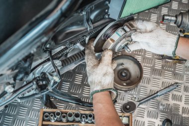 Motorcycle mechanic check the condition of Auto Transmission system or Clutch system of scooter at garage, repair and maintenance motorcycle concept.selective focus