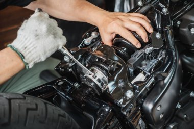 Motosiklet tamircisi ön yüklemeyi ayarlamak ve yay tünellerini, tamir ve bakım motorsiklet konseptini kilitlemek için anahtar kullanıyor. Seçici odak noktası