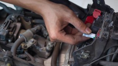 Motosiklet tamircisi sigortanın pilini değiştiriyor. motosiklet bakımı ve servis ve onarım konsepti, seçici odaklanma.