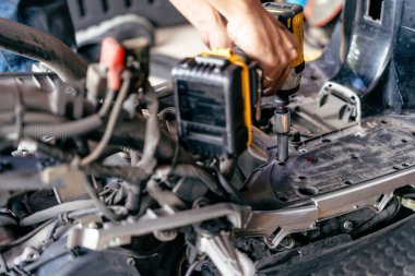 Tamirci garajda motorsikleti tamir etmek, onarım ve onarım için elektrikli tornavida ya da çarpma sürücüsü kullanır