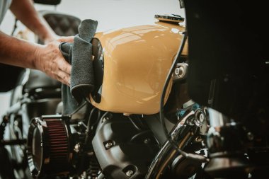 Motosikletli adam yakıt deposunu cilaladı ve cilaladı. tamir ve bakım motosiklet konsepti.    