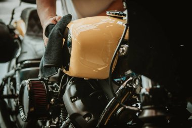 Motosikletli adam yakıt deposunu cilaladı ve cilaladı. tamir ve bakım motosiklet konsepti.