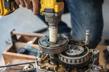 Tamirci, motor debriyajının fındık ve cıvatalarını sökmek ya da sıkmak için çarpma anahtarı kullanır. .