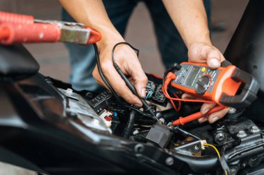 Çoklu kontrol motorlu elektrik sistemi kullanan tamirci elektrik tesisatında sorun buldu. Garajda çalışmak, motosiklet tamir konsepti , 