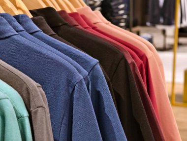 Mağazadaki askılarda asılı renkli tişörtler var. seçici odak 