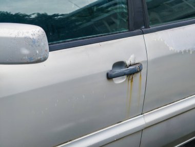 Paslı araba kapısı, soyulmuş boya, kapı kolunda pas hasarı. Araba bakımı ve vücut boyası konsepti.