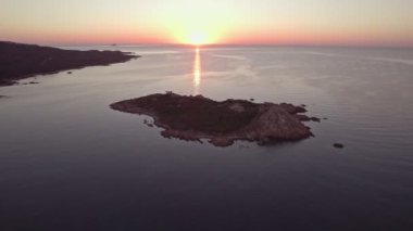 A mesmerizing aerial shot of the rocky island in mediterranean sea at early morning. Amazing footage of sunrise over the sea with a deep red colored sky