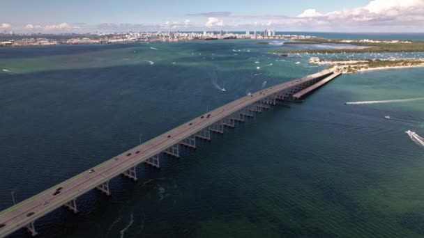 マイアミ フロリダのウィリアム パウエル橋の空中軌道ドローン撮影 サイティ スカイライン 車が橋を渡って運転している 青い緑色の水の上に浮かぶ船は — ストック動画