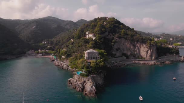 緑の木に囲まれた明るい晴れた日のイタリアのポルトフィーノの崖にプール付きの豪華なヴィラのパノラマビュー — ストック動画