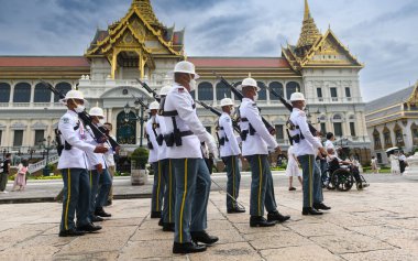 BANGKOK, THAILAND 30 Nisan 2023 beyaz cüppeli nöbetçiler vardiya değişimi için devriye geziyor. Gündüz vakti ışık alan Büyük Saray 'da..
