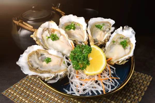 Fresh opened oysters in a plate with lemon on japanese style textured background