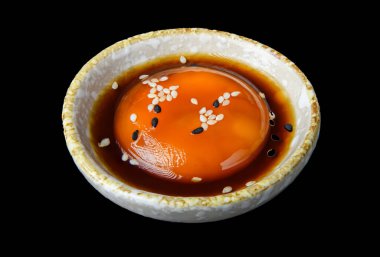 Japon usulü kaynamış yumurta soya soslu seramik bir kasede servis edilir ve üstü beyaz ve siyah susam tohumlarıyla kaplanır..