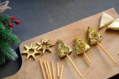 Kesme tahtasındaki ağaç biçimli peynirli atıştırmalık. Bir aperatifin yakın görüntüsü