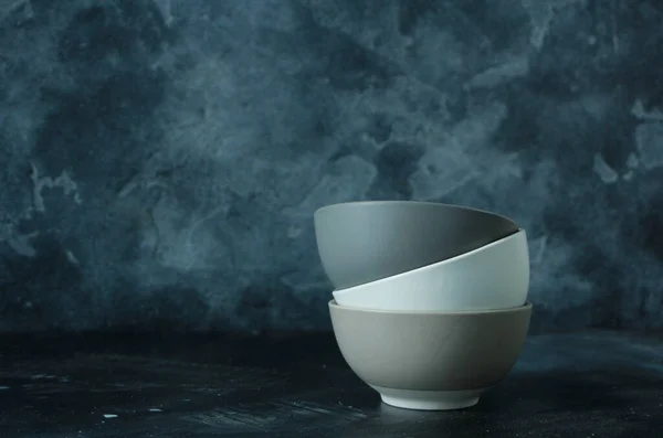 Three neutral-colors empty bowls on dark background