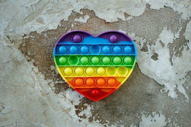 Renkli anti-stres duyusal duyusal oyuncak, kalp şeklinde, beton arka plan