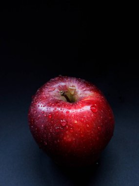 Kırmızı elma üzerine su damlaları, koyu arkaplan. Kırmızı elma, koyu arkaplan, su damlaları