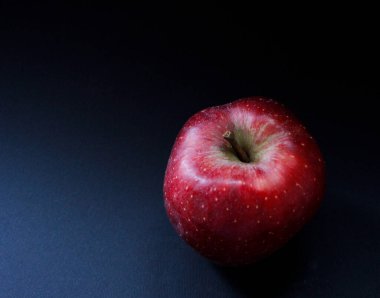 Koyu arkaplanda taze kırmızı elma ve metin için boşluk. Organik. Koyu. Kırmızı