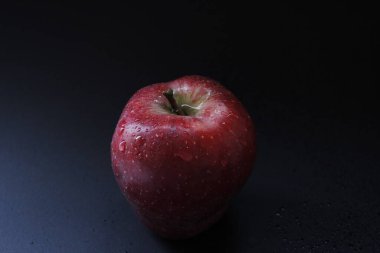 Koyu arkaplanda taze kırmızı elma ve metin için boşluk. Organik. Koyu.