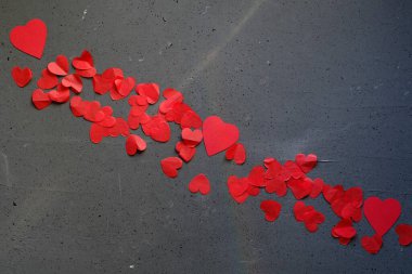 Red small hearts on dark background, creative layout