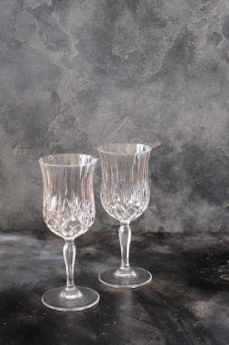 Two empty glasses on dark color background. Minimalist style photography.