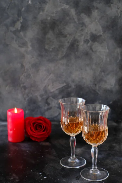 Two glasses of rose lemonade and a red rose on a dark background. Minimalist style photography. Love. Romantic dinner.