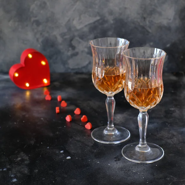 Two glasses of rose lemonade and a red rose on a dark background. Minimalist style photography. Love. Romantic dinner.