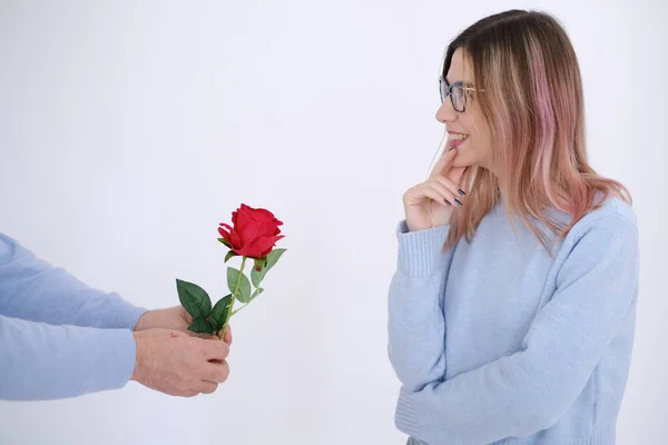 Love scene. Man giving red rose to his lover. White background. Minimalist style photography. Love.