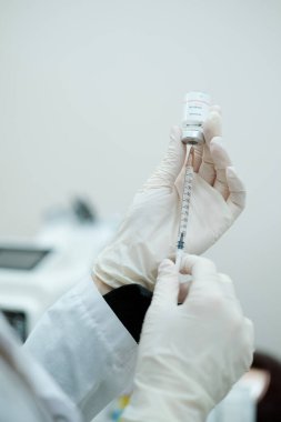 Kozmetik uzmanı serum şişesinden şırıngaya mezoterapi serumu koydu. Yüz tedavi prosedürü 