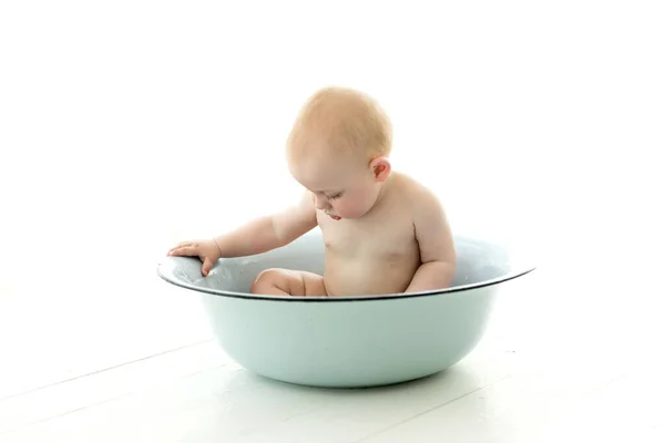 stock image cute baby boy sitting on white towel, isolated on a light background