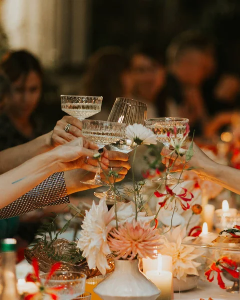 Cheers! Group of people cheering with champagne flutes with wedding interior in the background