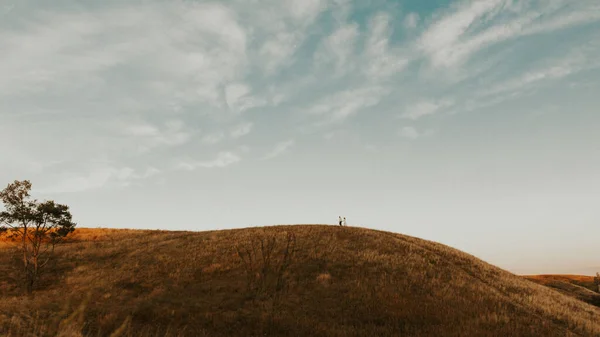 カップルが山を歩いている 真ん中の幸せなカップルとマウンテンラズケープ マウンテンフィールドの風景を走るカップル ストック写真