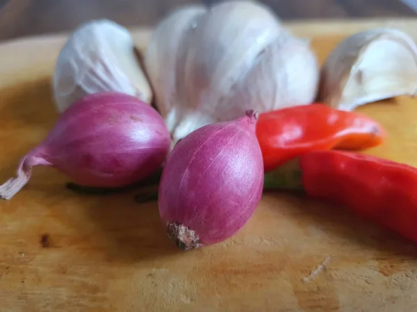 调料或调味材料为厨房食谱 木制切菜板上的白色大蒜 辣椒和红洋葱 — 图库照片