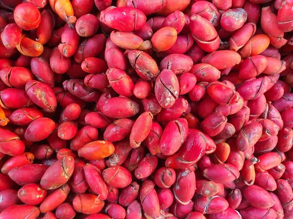 stock image Bulk of fresh melinjo fruits or gnetum gnemon with red skin in traditional market.