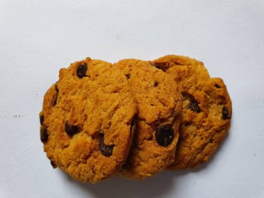 Beyaz arka planda çikolata parçalı çıtır kurabiyeler.