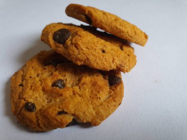 Beyaz arka planda çikolata parçalı çıtır kurabiyeler.